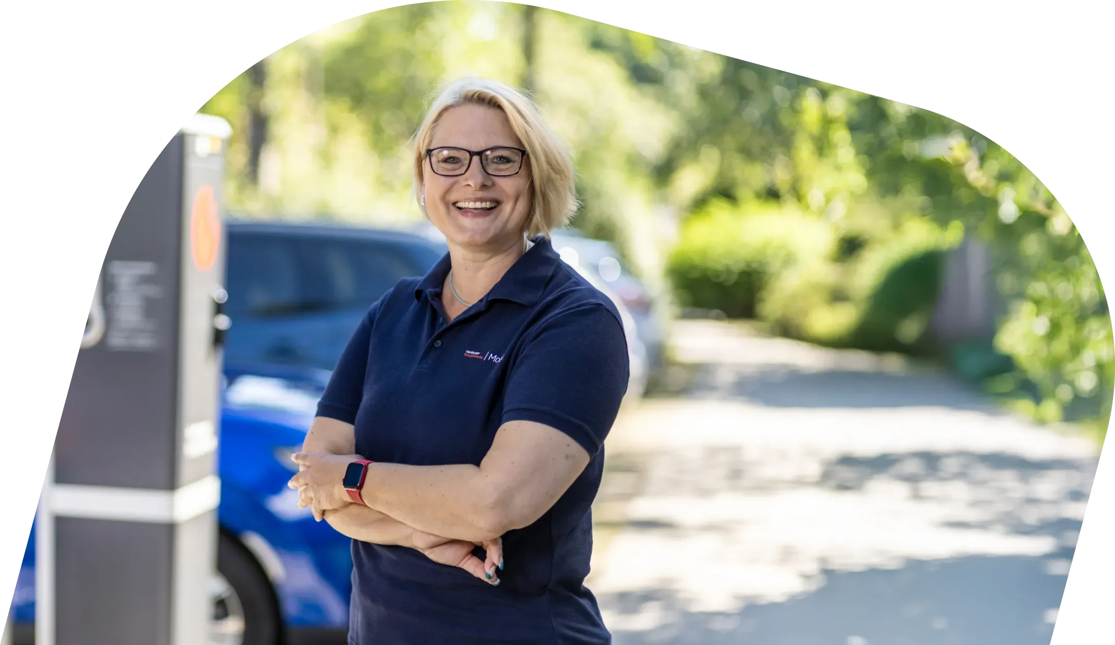 Kontaktbereich mit Überschrift „Kontakt“ und Text, der dazu einlädt, gemeinsam die Mobilitätswende in Hamburg zu gestalten, sowie Hinweisen, vorab über Zeitplan, Budget, Bedarf und Eigentumsverhältnisse nachzudenken; rechts daneben eine Person in Dienstkleidung an einer Ladesäule.